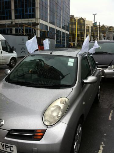 Car with hand drawn banners in a street